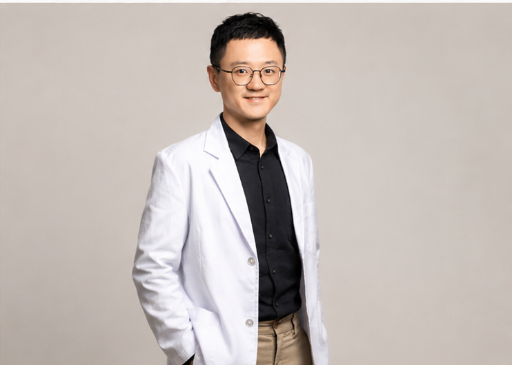 徐維廷諮商心理師,穿著白袍、戴眼鏡,微笑看向鏡頭 / Wei-Ting Hsu, counseling psychologist, wearing glasses and a white coat, smiling at the camera